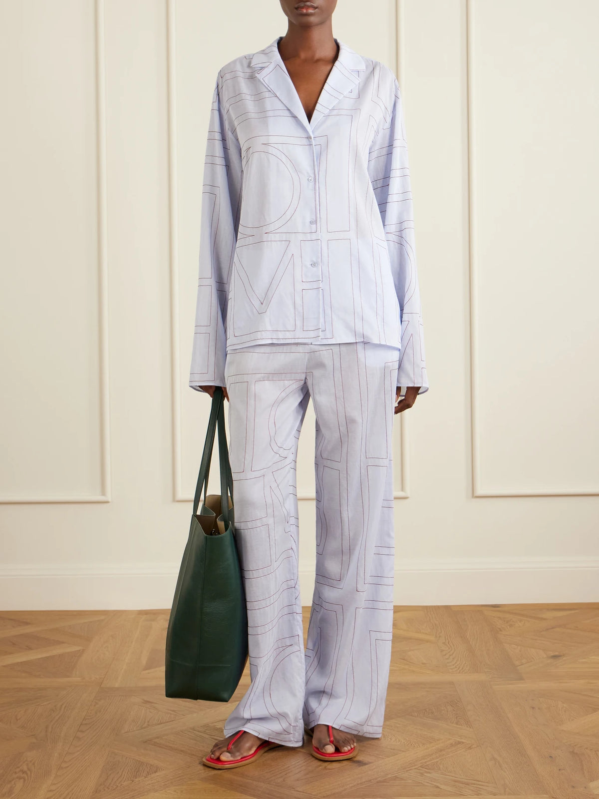 Image of a model wearing Pants. Product name - Embroidered Lyocell And Cotton-blend Wide-leg Pajama Pants in Light blue colour by brand - TOTEME