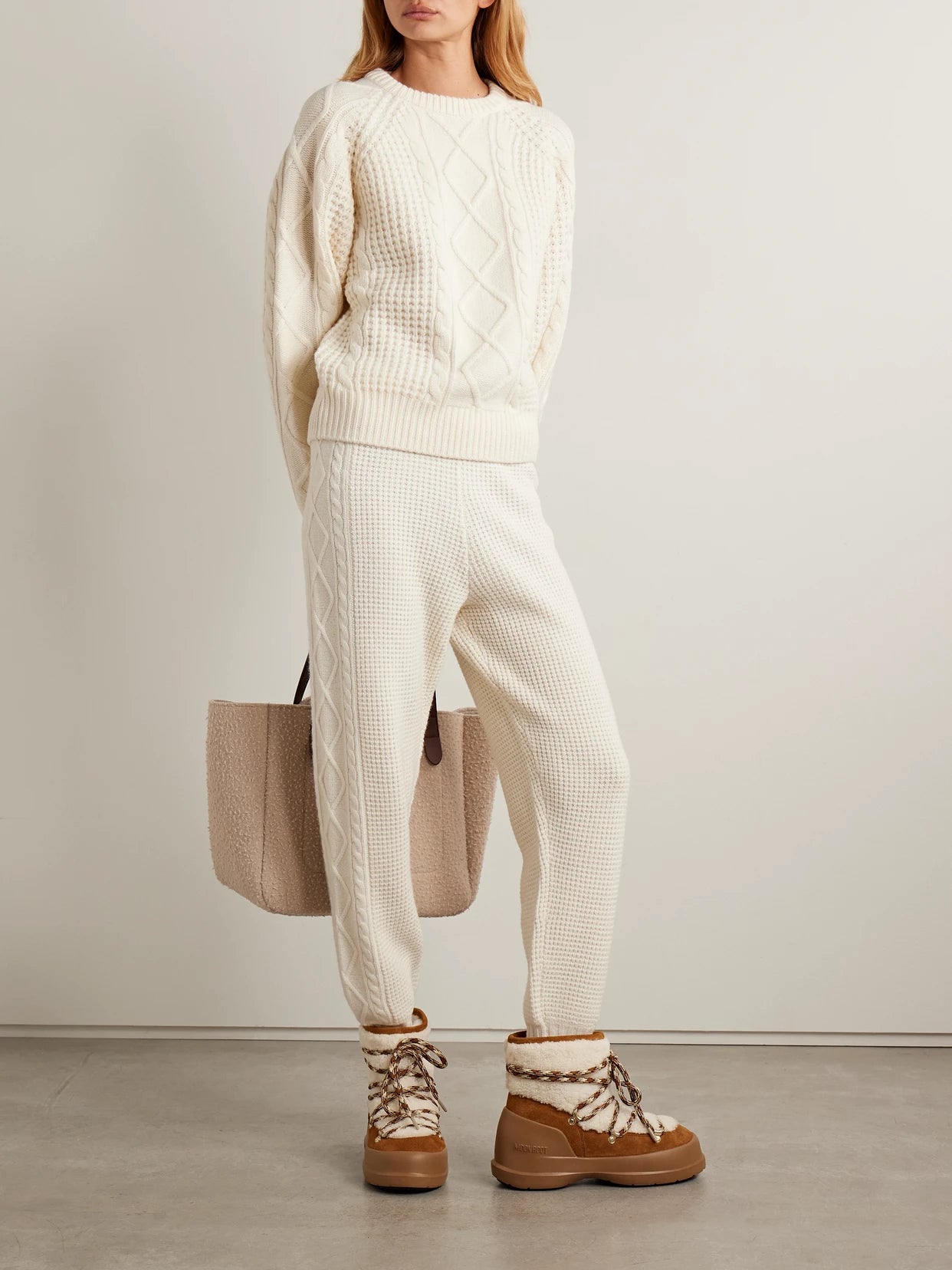 Image of a model wearing Outerwear. Product name - Crystal Cable-knit Merino Wool Sweater in Cream colour by brand - Perfect Moment
