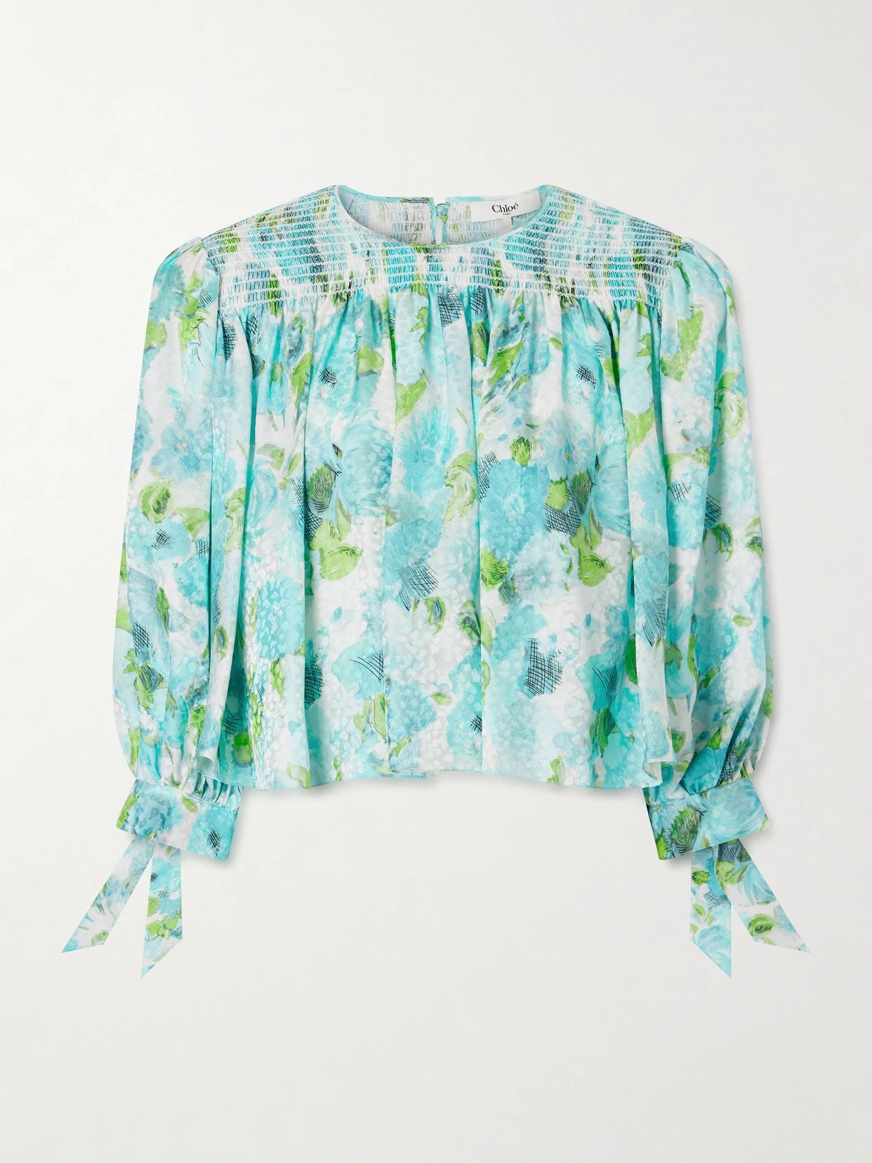 Image of a model wearing Tops. Product name - Cropped Smocked Floral-print Silk-jacquard Blouse in Blue colour by brand - Chloé