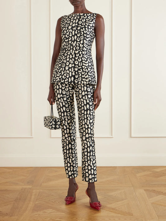 Image of a model wearing Pants. Product name - Leopard-patterned Jacquard Slim-leg Pants in Black colour by brand - Carolina Herrera