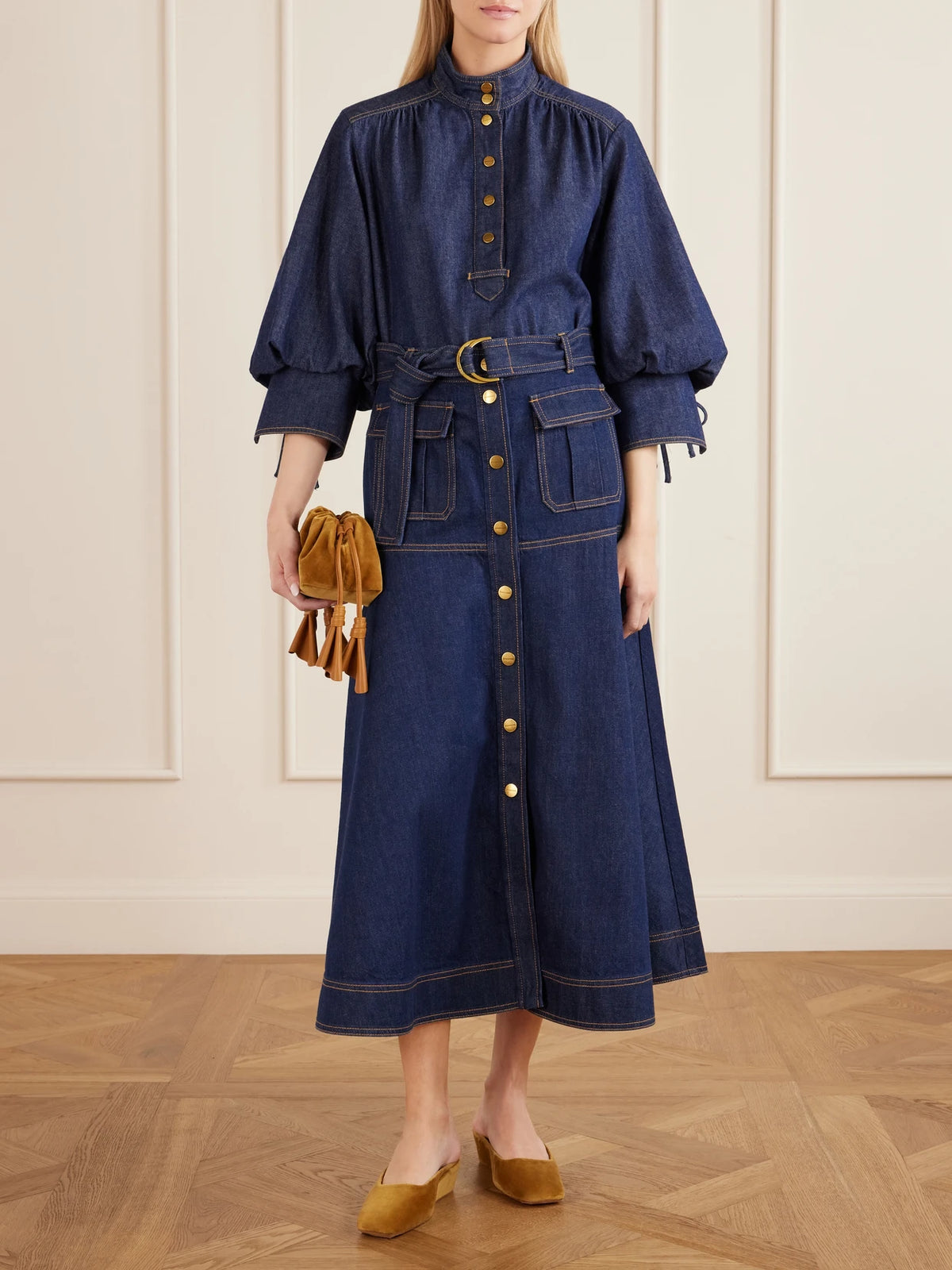 Image of a model wearing Skirts. Product name - Belted Denim Midi Skirt in Blue colour by brand - Zimmermann