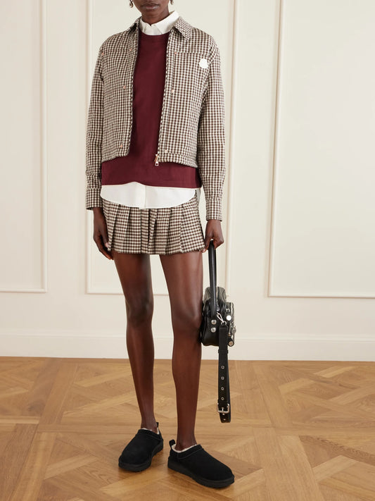 Image of a model wearing Skirts. Product name - Appliquéd Pleated Gingham Cotton-blend Mini Skirt in Brown colour by brand - Moncler