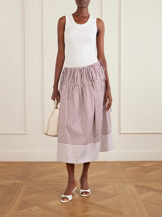 Image of a model wearing Skirts. Product name - Eve Tiered Checked Cotton Midi Skirt in Burgundy colour by brand - LIBEROWE