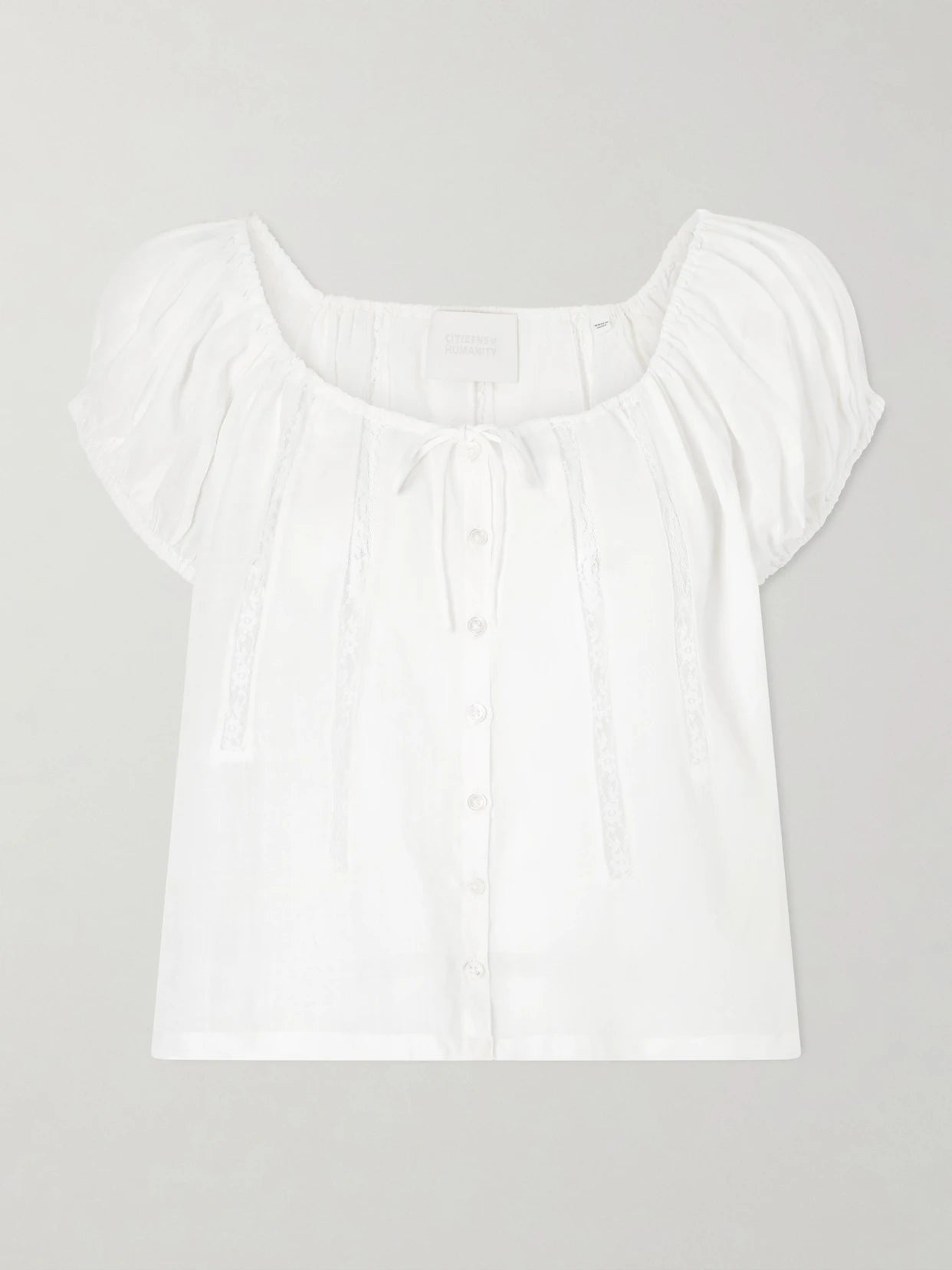 Image of a model wearing Tops. Product name - Tatev Tie-detailed Lace-trimmed Ramie Blouse in White colour by brand - Citizens of Humanity