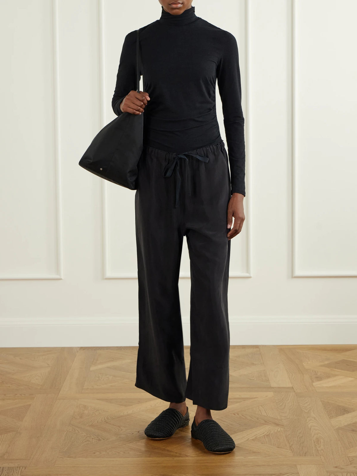 Image of a model wearing Pants. Product name - Silk-habotai Wide-leg Drawstring Pants in Black colour by brand - James Perse