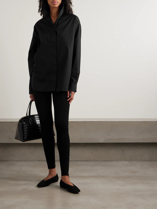 Image of a model wearing Tops. Product name - Sharp Oversized Cotton-poplin Shirt in Black colour by brand - TOTEME