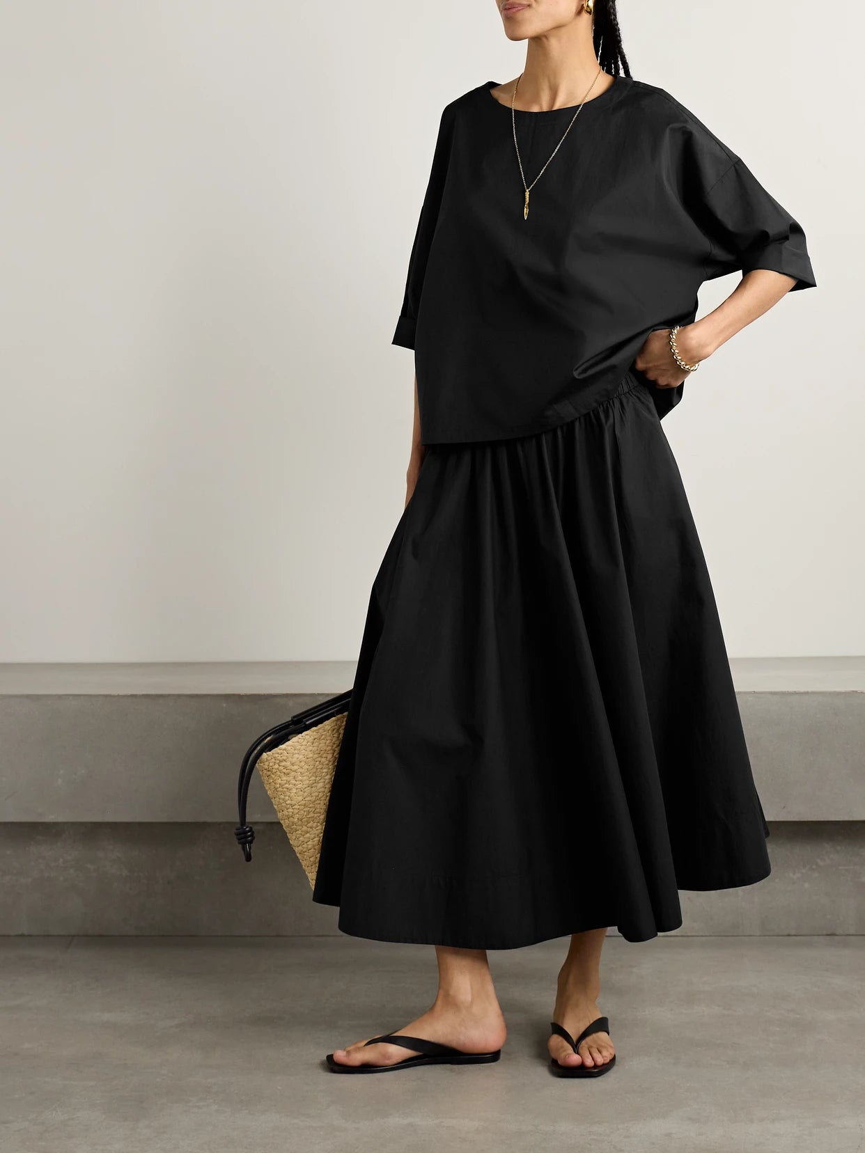 Image of a model wearing Skirts. Product name - The Kyria Gathered Cotton-poplin Midi Skirt in Black colour by brand - Suzie Kondi