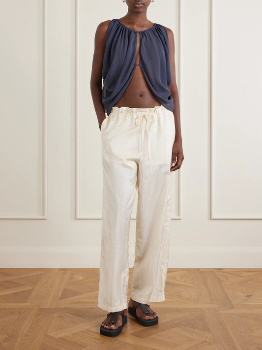 Image of a model wearing Pants. Product name - Morocco Cotton And Silk-blend Habotai Wide-leg Pants in Ivory colour by brand - AFLALO