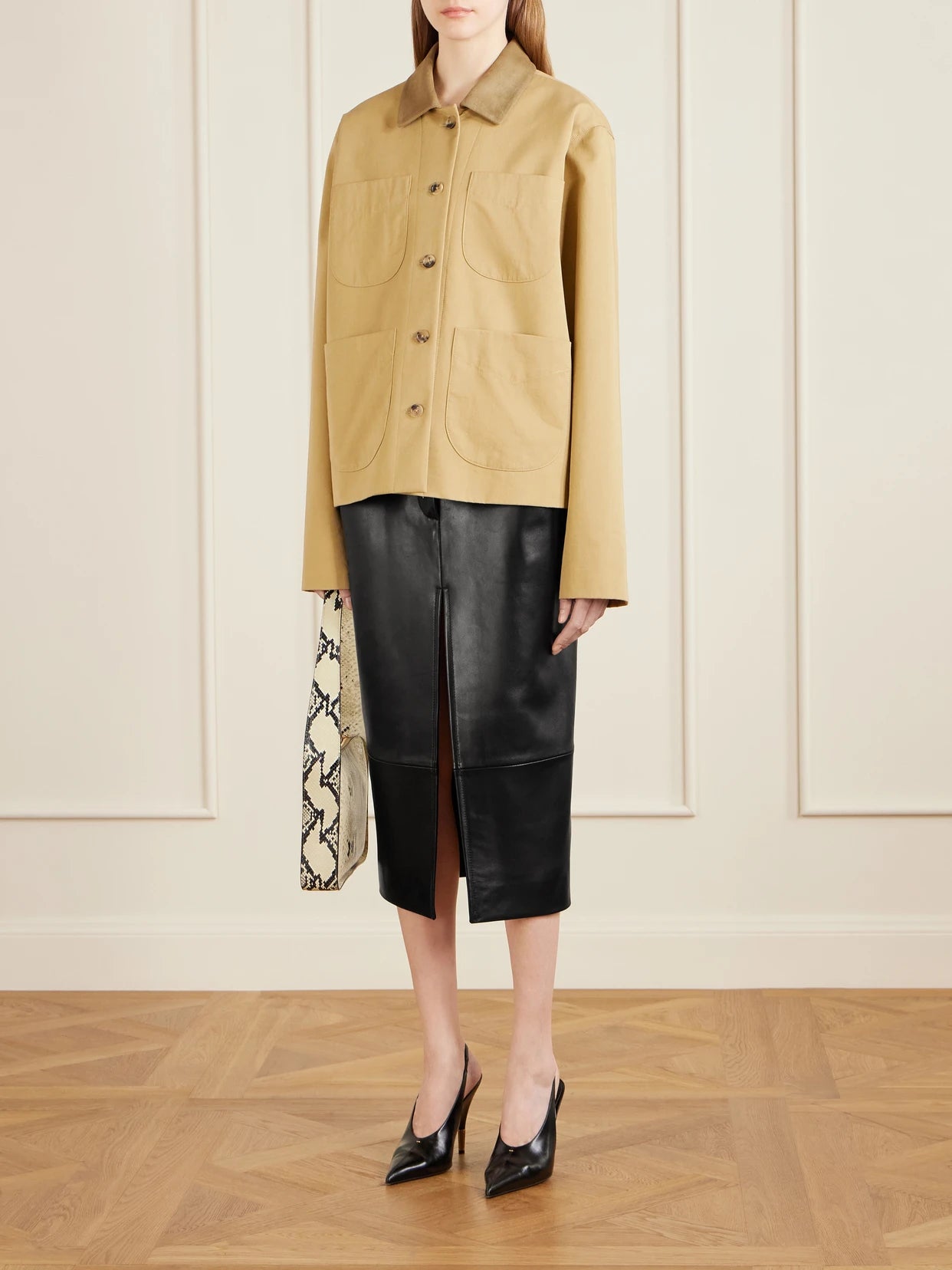 Image of a model wearing Skirts. Product name - Anden Paneled Leather Midi Skirt in Black colour by brand - KHAITE