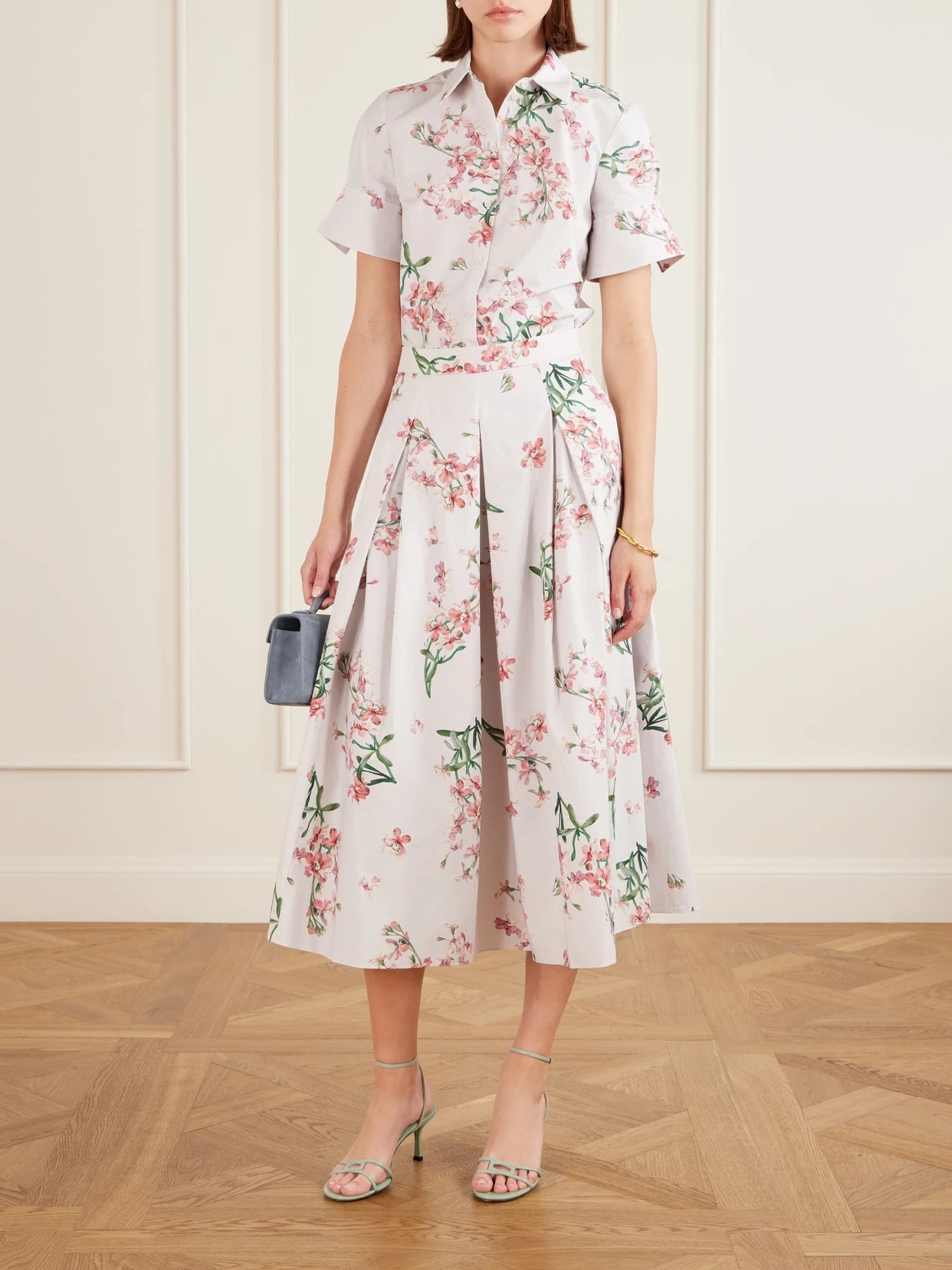 Image of a model wearing Skirts. Product name - Pleated Floral-print Cotton-poplin Midi Skirt in White colour by brand - Erdem