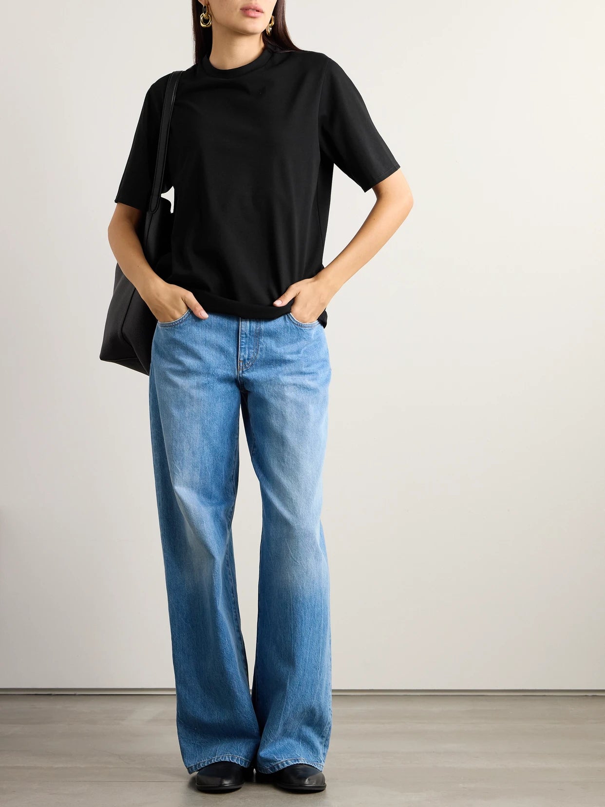 Image of a model wearing Tops. Product name - Essentials Chiara Cotton-jersey T-shirt in Black colour by brand - The Row