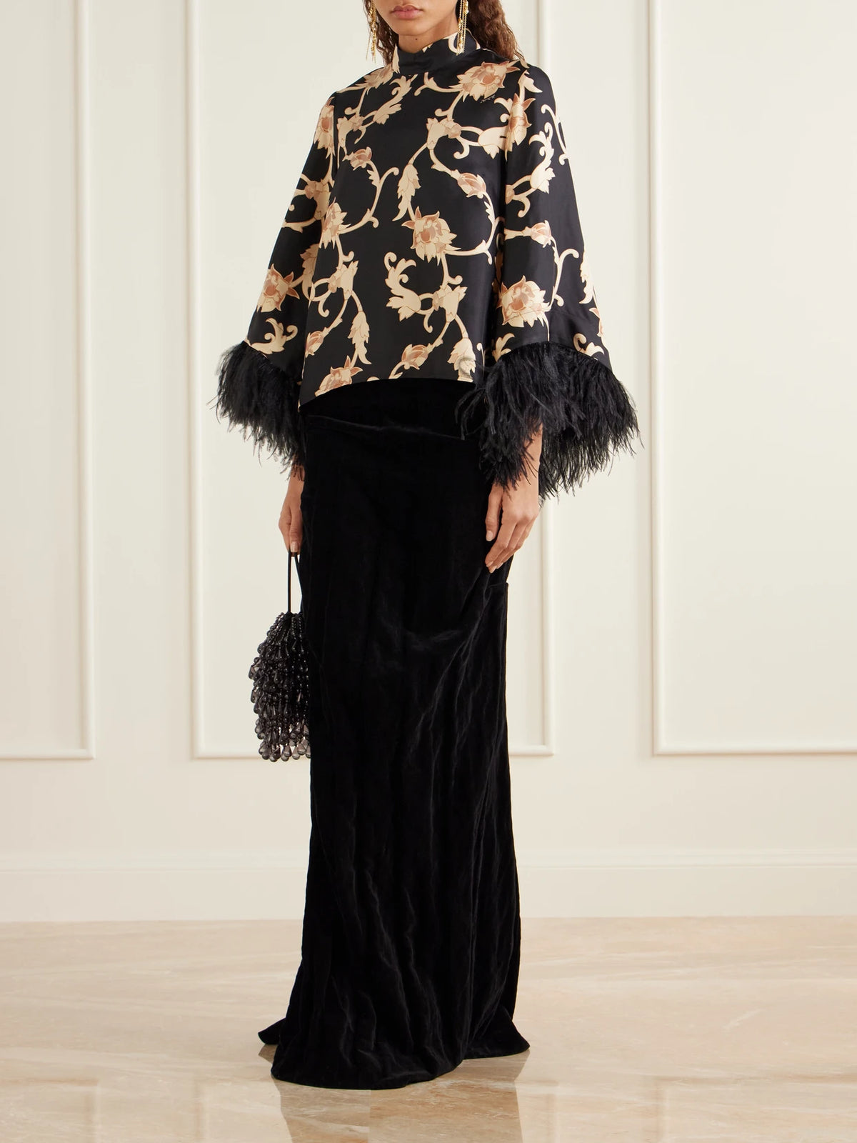 Image of a model wearing Tops. Product name - Make An Exit Feather-trimmed Printed Silk-twill Blouse in Black colour by brand - La DoubleJ