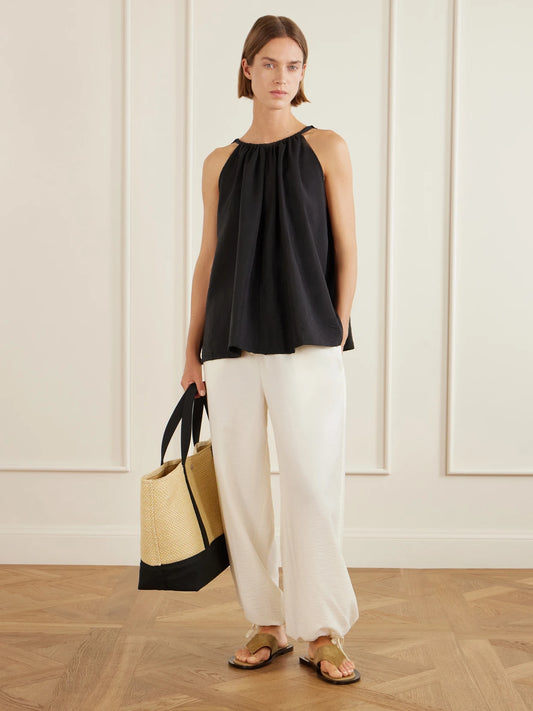 Image of a model wearing Pants. Product name - Parachute Lyocell-blend Balloon Pants in Ecru colour by brand - TOTEME