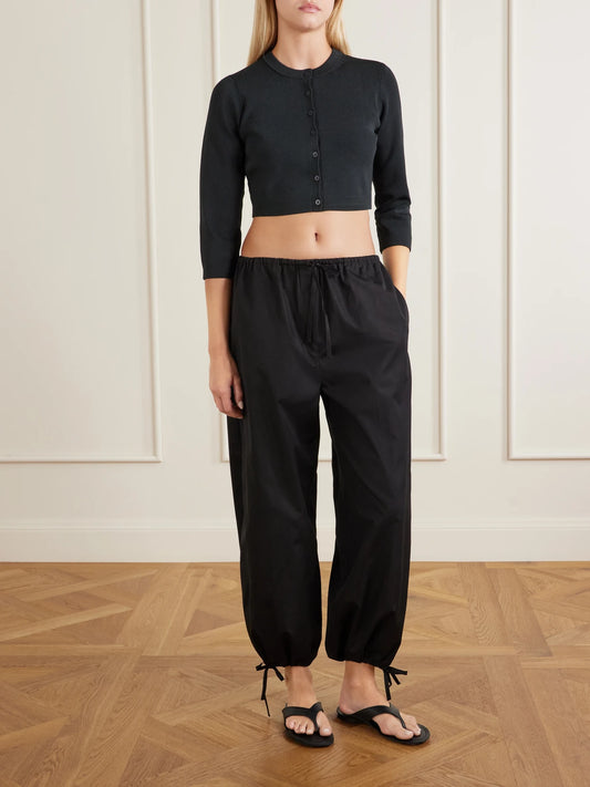 Image of a model wearing Tops. Product name - Refined Knit Cropped Ribbed Stretch-jersey Cardigan - Obsidian in Black colour by brand - SKIMS