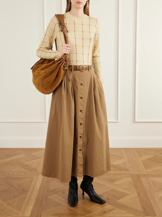 Image of a model wearing Skirts. Product name - The Venetian Pleated Cotton-twill Midi Skirt in Camel colour by brand - Jamie Haller