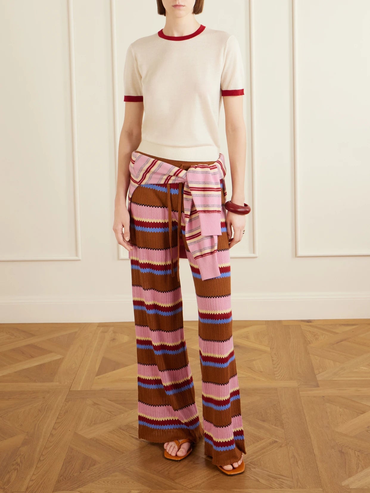 Image of a model wearing Pants. Product name - Palazzo Striped Ribbed Silk And Linen-blend Wide-leg Pants in Pink colour by brand - Guest In Residence