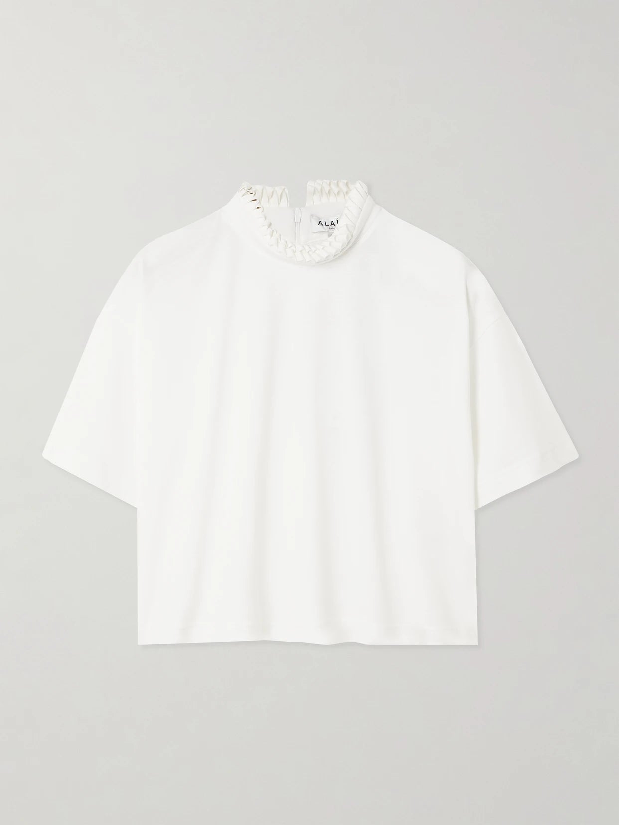 Image of a model wearing Tops. Product name - Cropped Ruffled Cotton-jersey Turtleneck T-shirt in White colour by brand - Alaïa