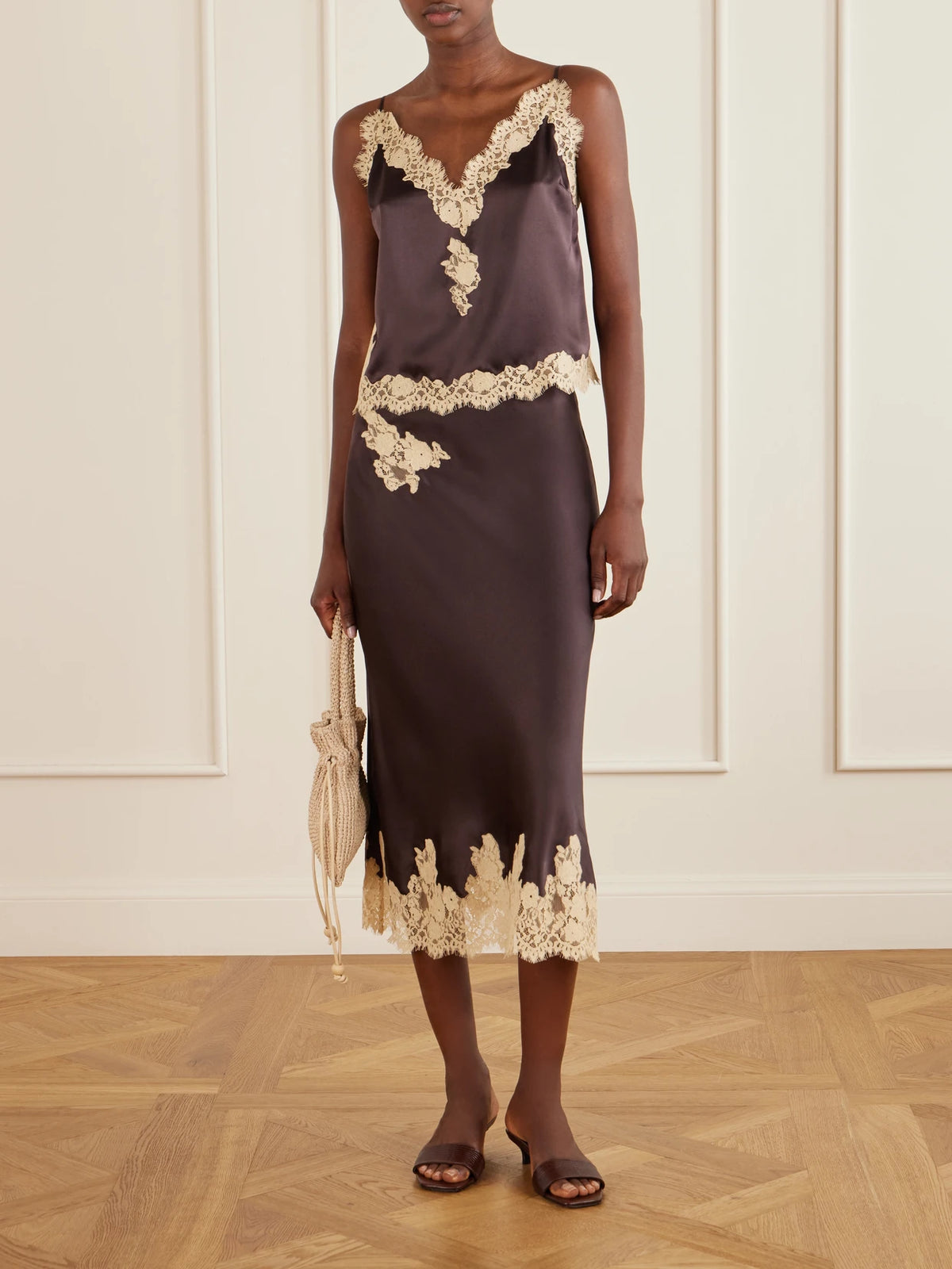 Image of a model wearing Skirts. Product name - Lace-trimmed Silk-satin Midi Skirt in Brown colour by brand - DÔEN