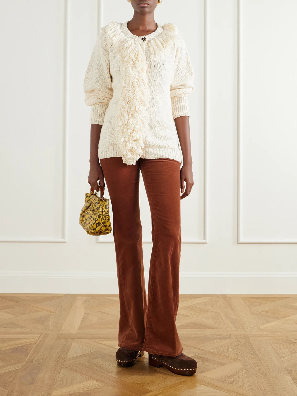 Image of a model wearing Outerwear. Product name - Sami Fringe-trimmed Open-knit Cotton Cardigan in Off-white colour by brand - ALIX OF BOHEMIA