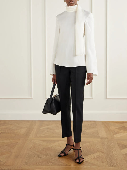 Image of a model wearing Pants. Product name - Pintucked Grain De Poudre Slim-fit Pants in Black colour by brand - RÓHE