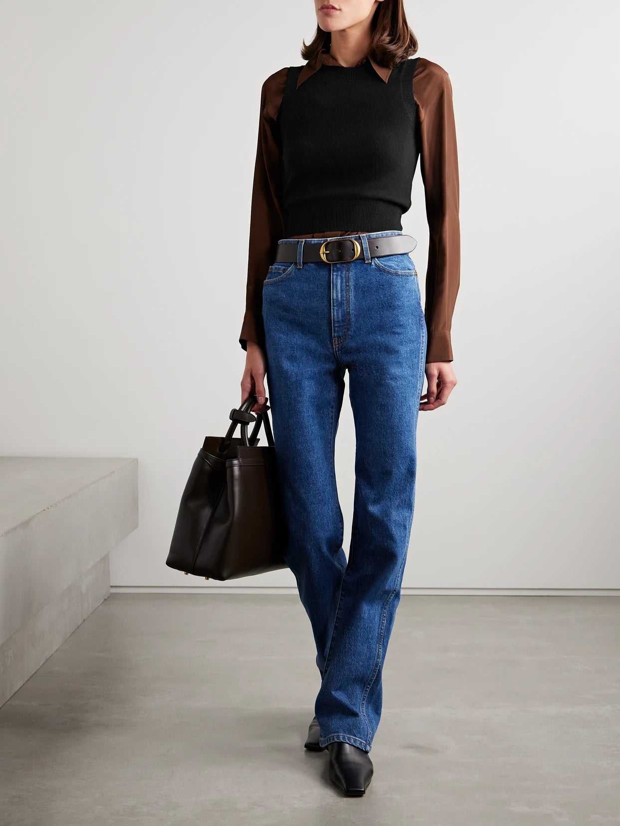 Image of a model wearing Outerwear. Product name - May Cropped Cashmere Tank in Black colour by brand - Nili Lotan