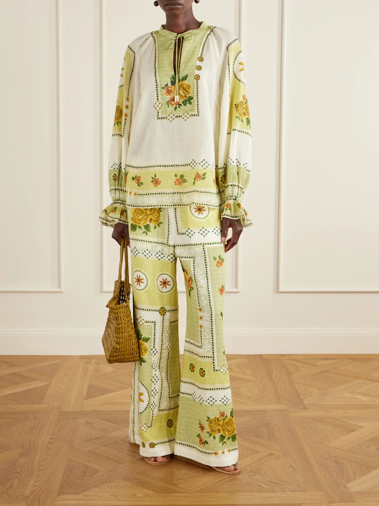 Image of a model wearing Pants. Product name - Dixie Knotted Floral-print Linen Pants in Green colour by brand - ALÉMAIS