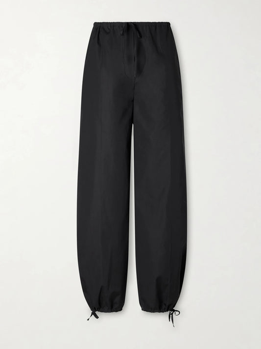 Image of a model wearing Pants. Product name - Cotton Wide-leg Cotton Balloon Pants in Black colour by brand - TOTEME