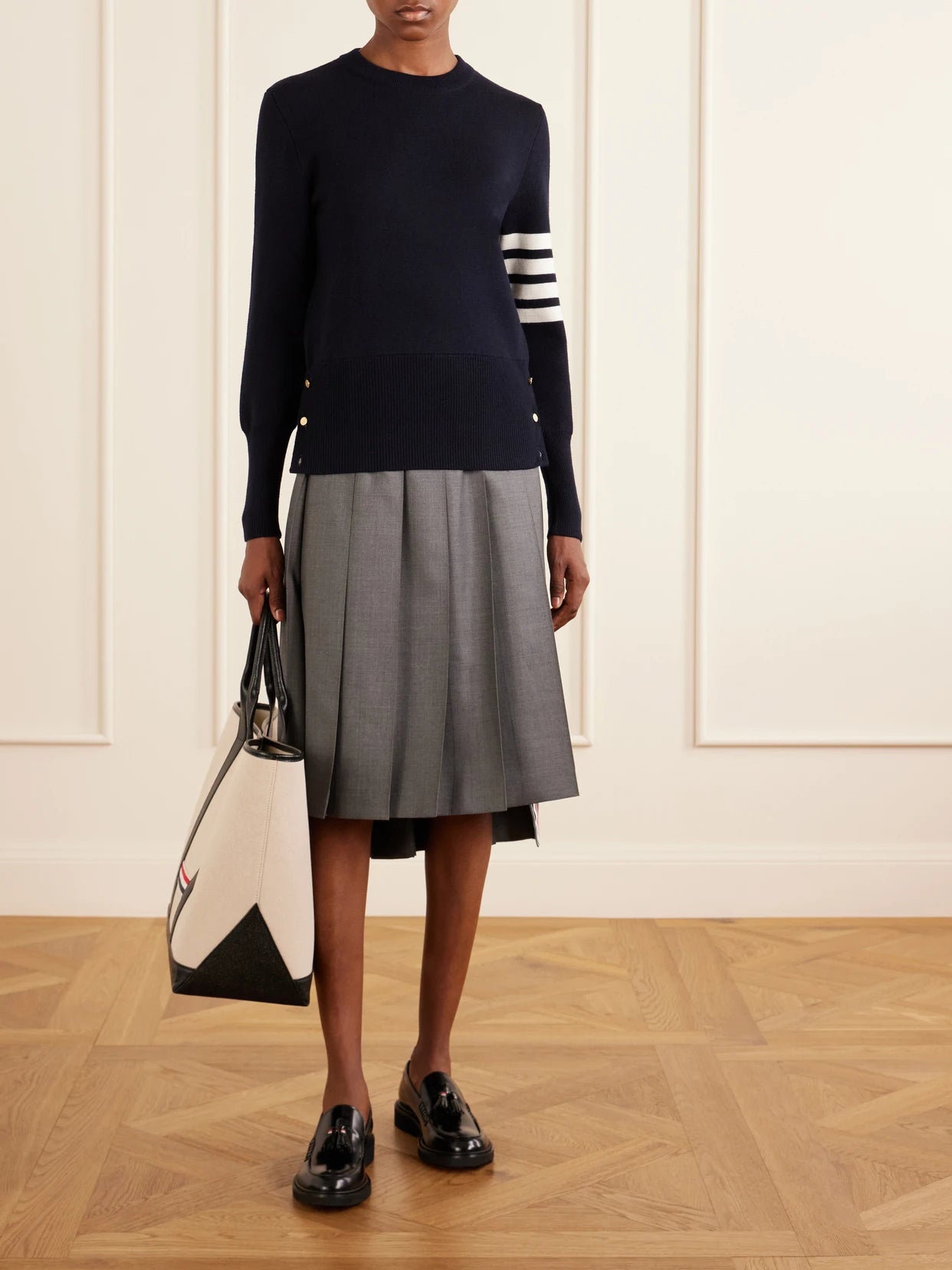 Image of a model wearing Outerwear. Product name - Grosgrain-trimmed Striped Wool Sweater in Navy colour by brand - Thom Browne