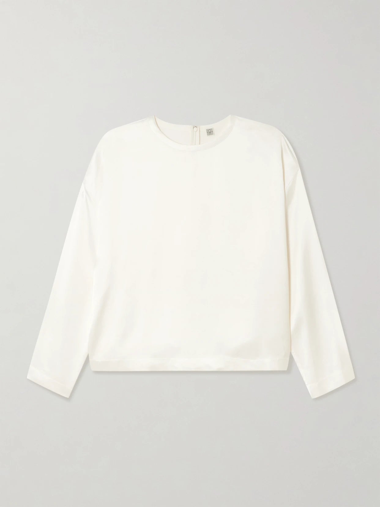 Image of a model wearing Tops. Product name - Satin Top in White colour by brand - TOTEME
