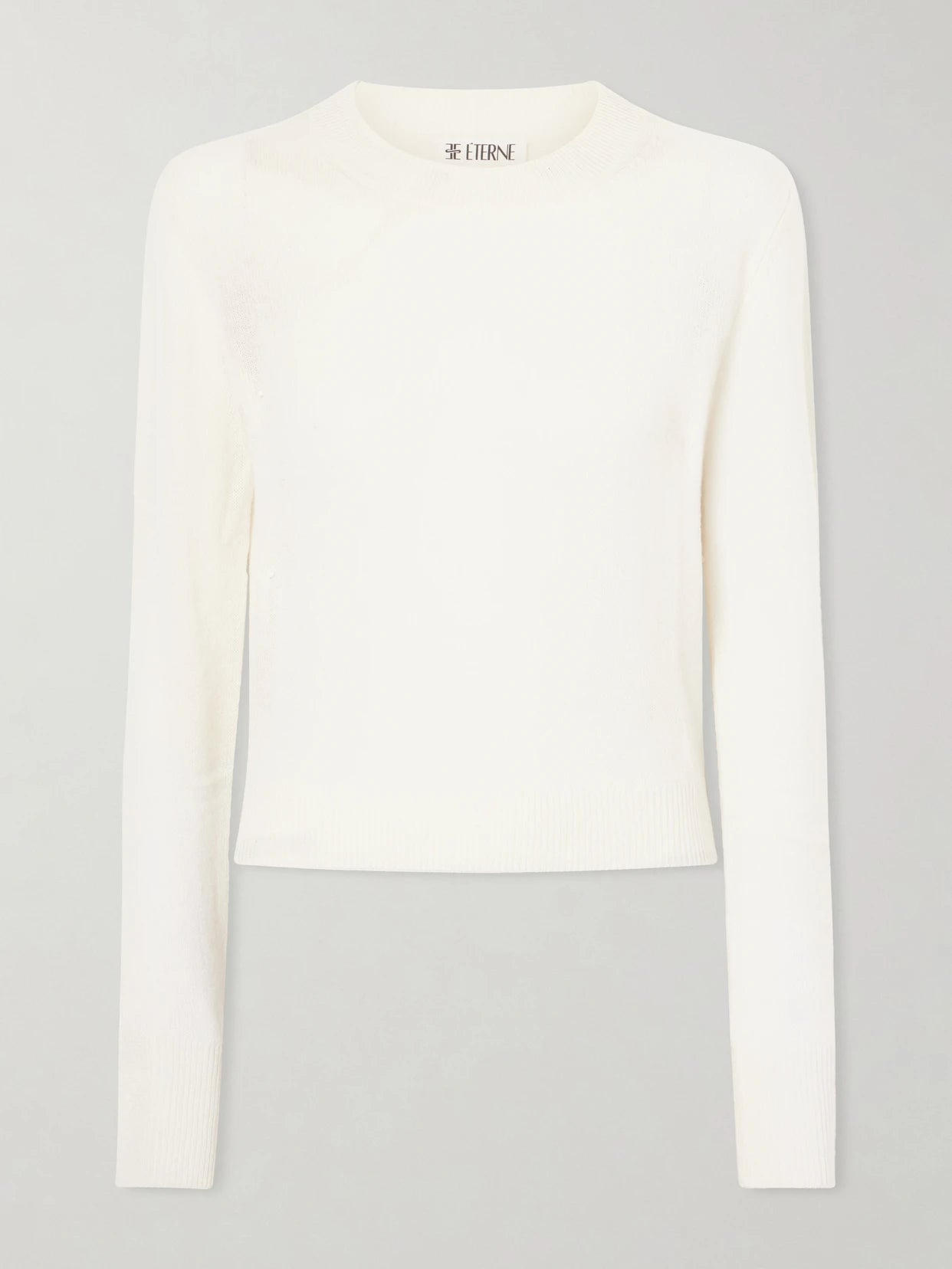 Image of a model wearing Outerwear. Product name - Francis Cashmere Sweater in Cream colour by brand - ÉTERNE