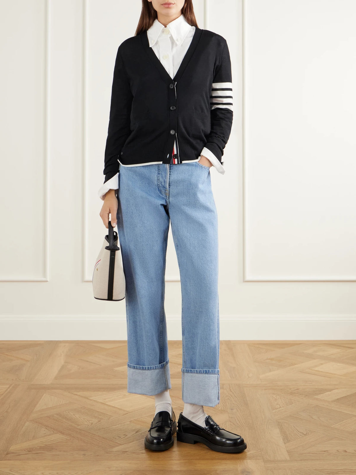 Image of a model wearing Outerwear. Product name - 4-bar Wool Cardigan in Black colour by brand - Thom Browne