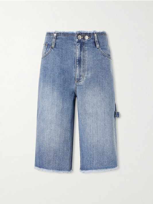 Image of a model wearing Shorts. Product name - Mid-rise Denim Straight-leg Shorts in Mid denim colour by brand - Tibi