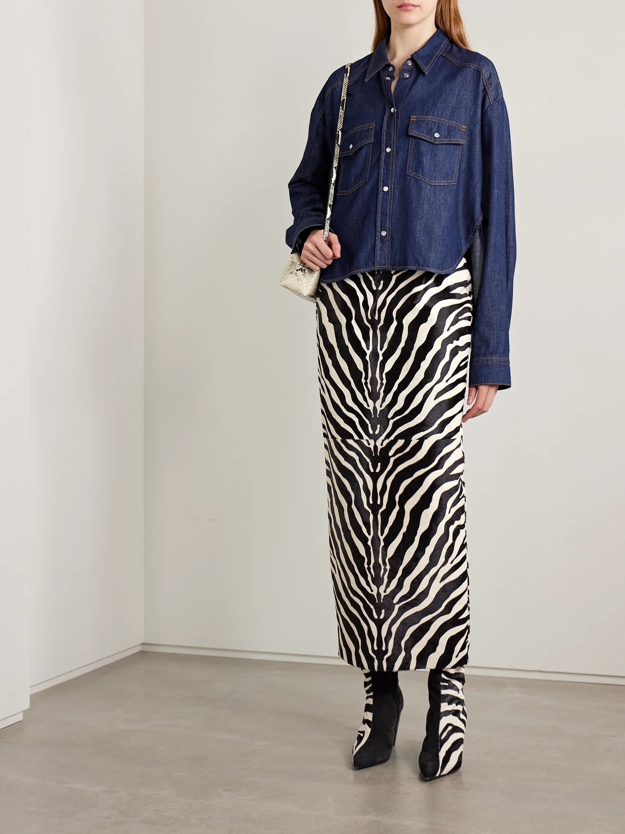 Image of a model wearing Skirts. Product name - Loxley Zebra-print Calf Hair Midi Skirt in Zebra print colour by brand - KHAITE