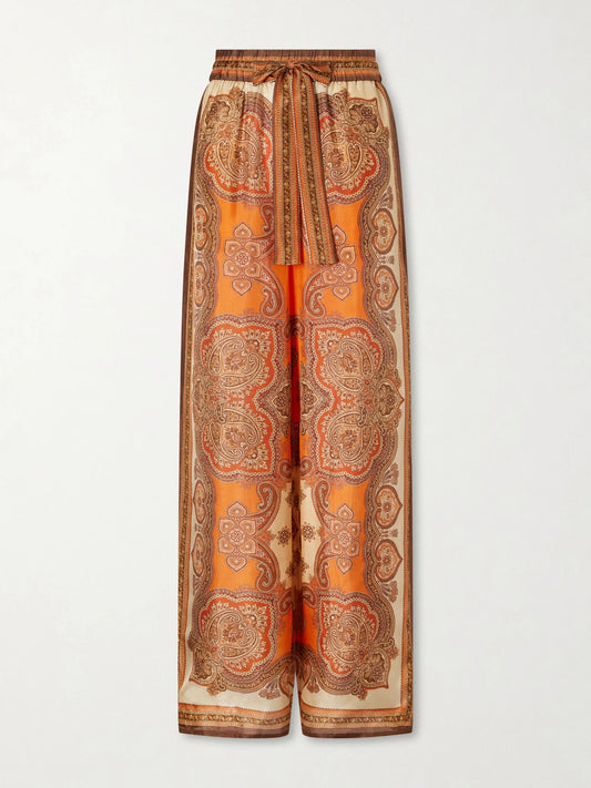 Image of a model wearing Pants. Product name - Mahon Printed Silk-satin Wide-leg Pants in Brown colour by brand - Zimmermann
