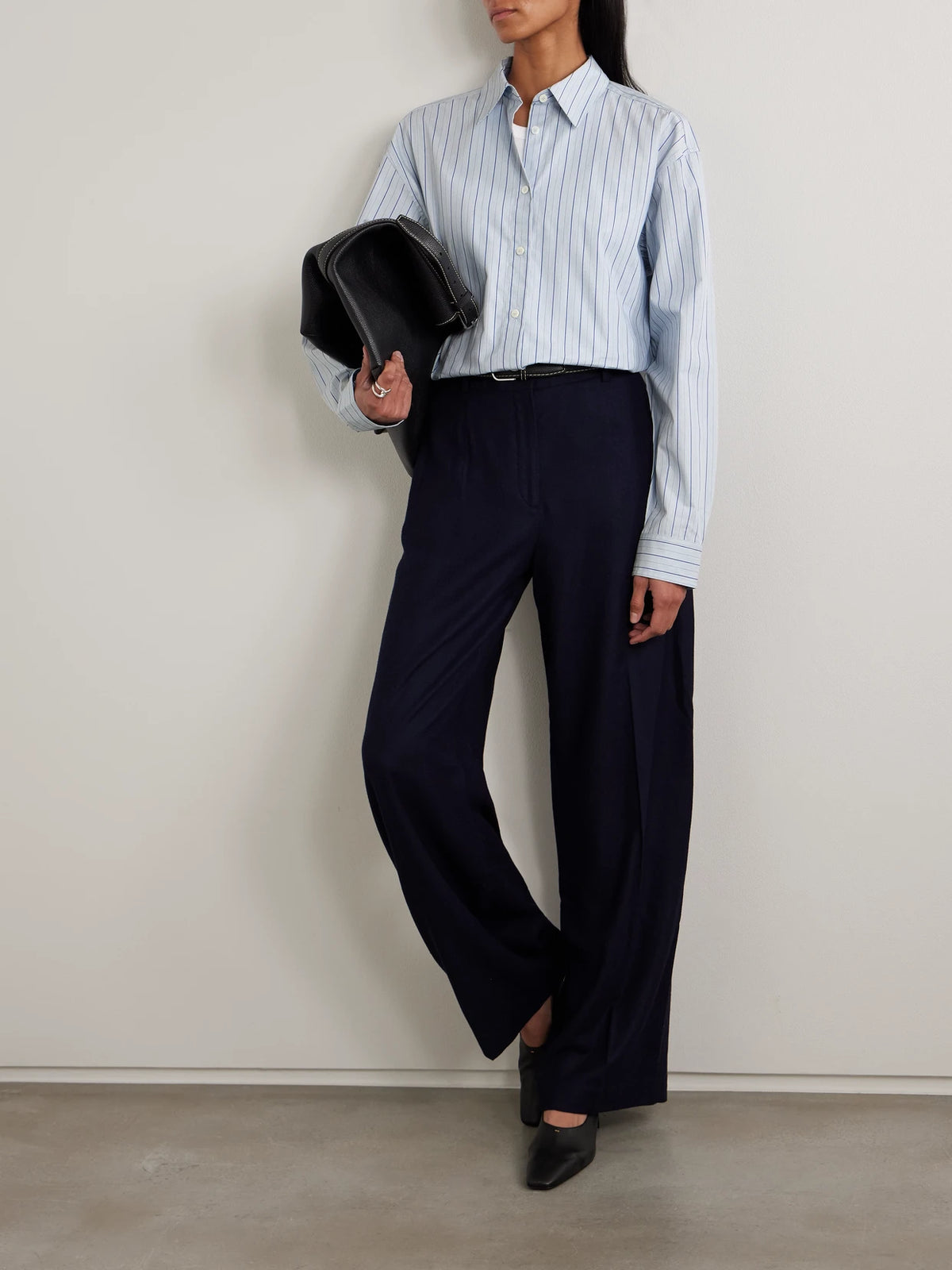 Image of a model wearing Tops. Product name - Striped Cotton-poplin Shirt in Light blue colour by brand - TOTEME
