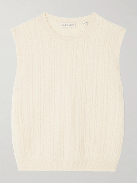 Image of a model wearing Outerwear. Product name - Louden Cropped Cable-knit Cashmere Sweater Vest in Cream colour by brand - DÔEN