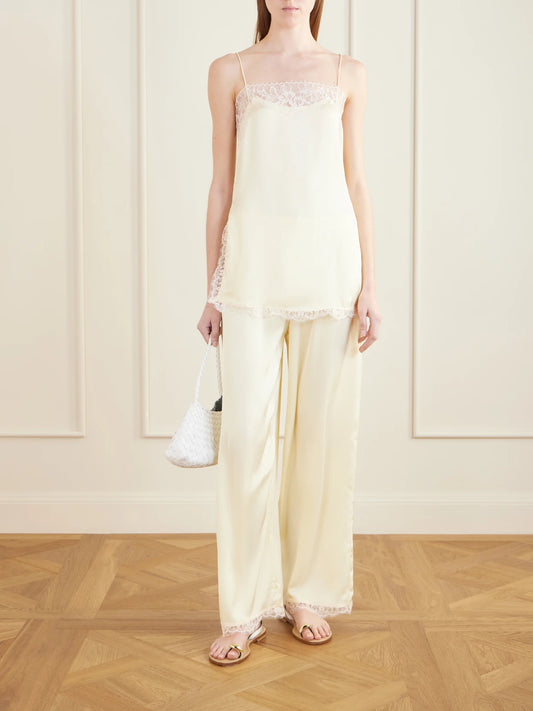 Image of a model wearing Tops. Product name - Adnina Lace-trimmed Recycled-satin Top in Yellow colour by brand - Faithfull
