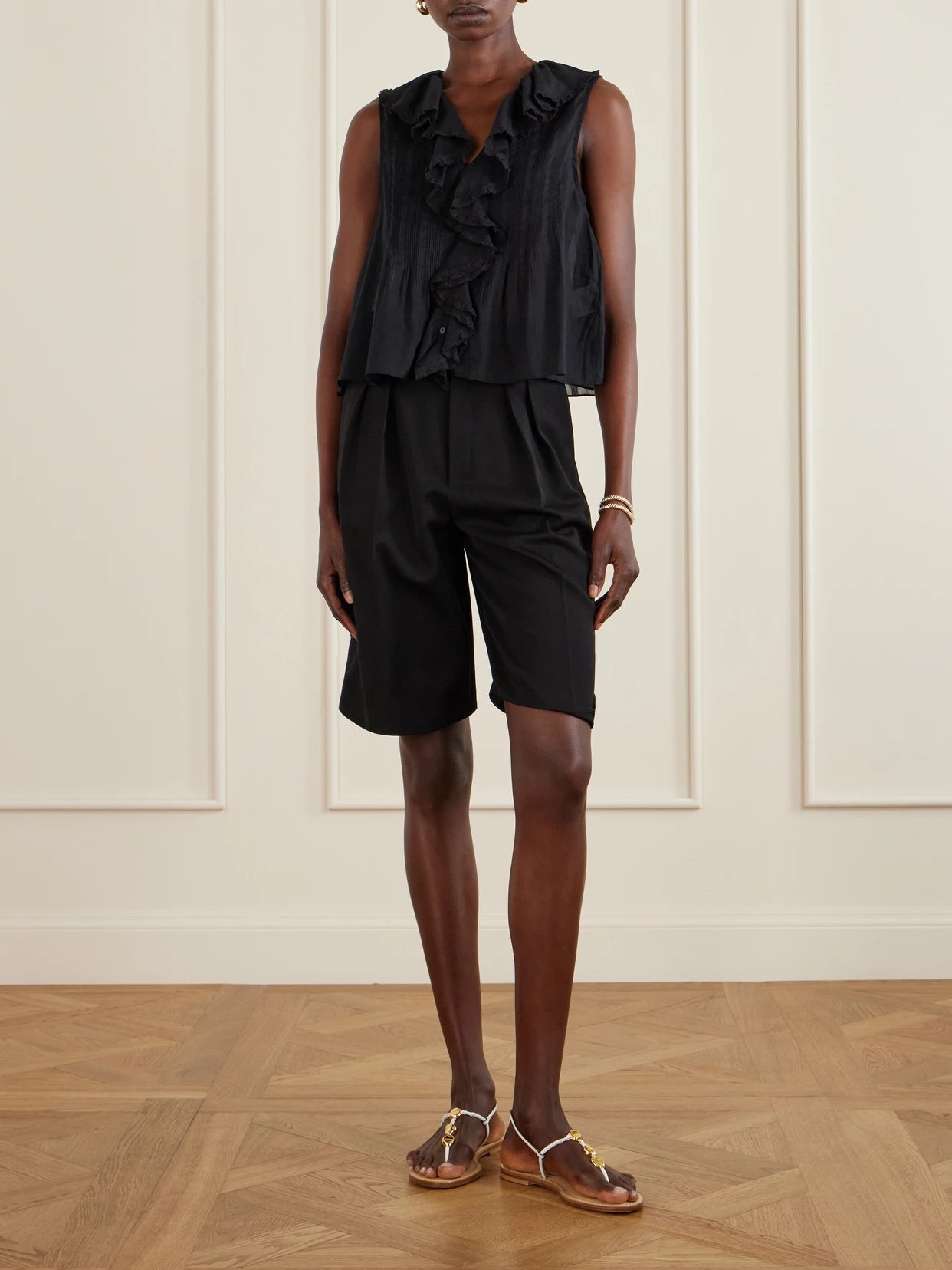 Image of a model wearing Tops. Product name - Hilda Ruffled Embroidered Organic Cotton Top in Black colour by brand - DÔEN