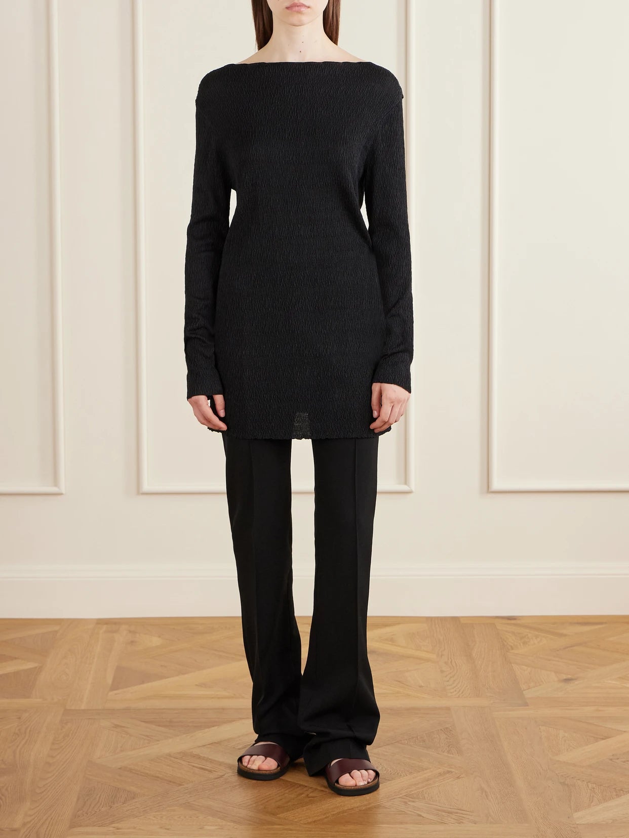 Image of a model wearing Outerwear. Product name - Ozma Pleated Silk Top in Black colour by brand - The Row