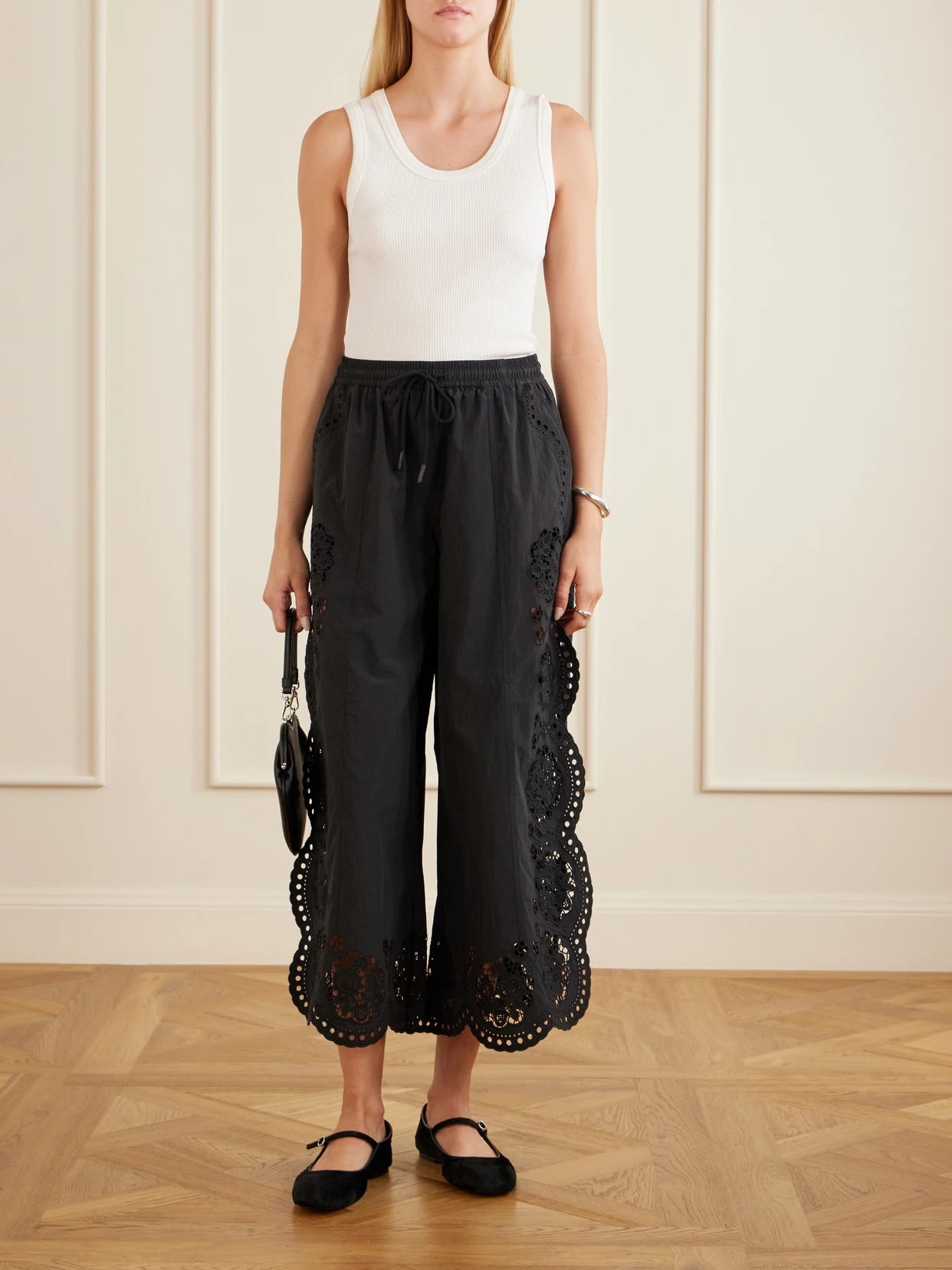 Image of a model wearing Pants. Product name - Vittoria Broderie Anglaise-trimmed Shell Wide-leg Pants in Black colour by brand - Sea