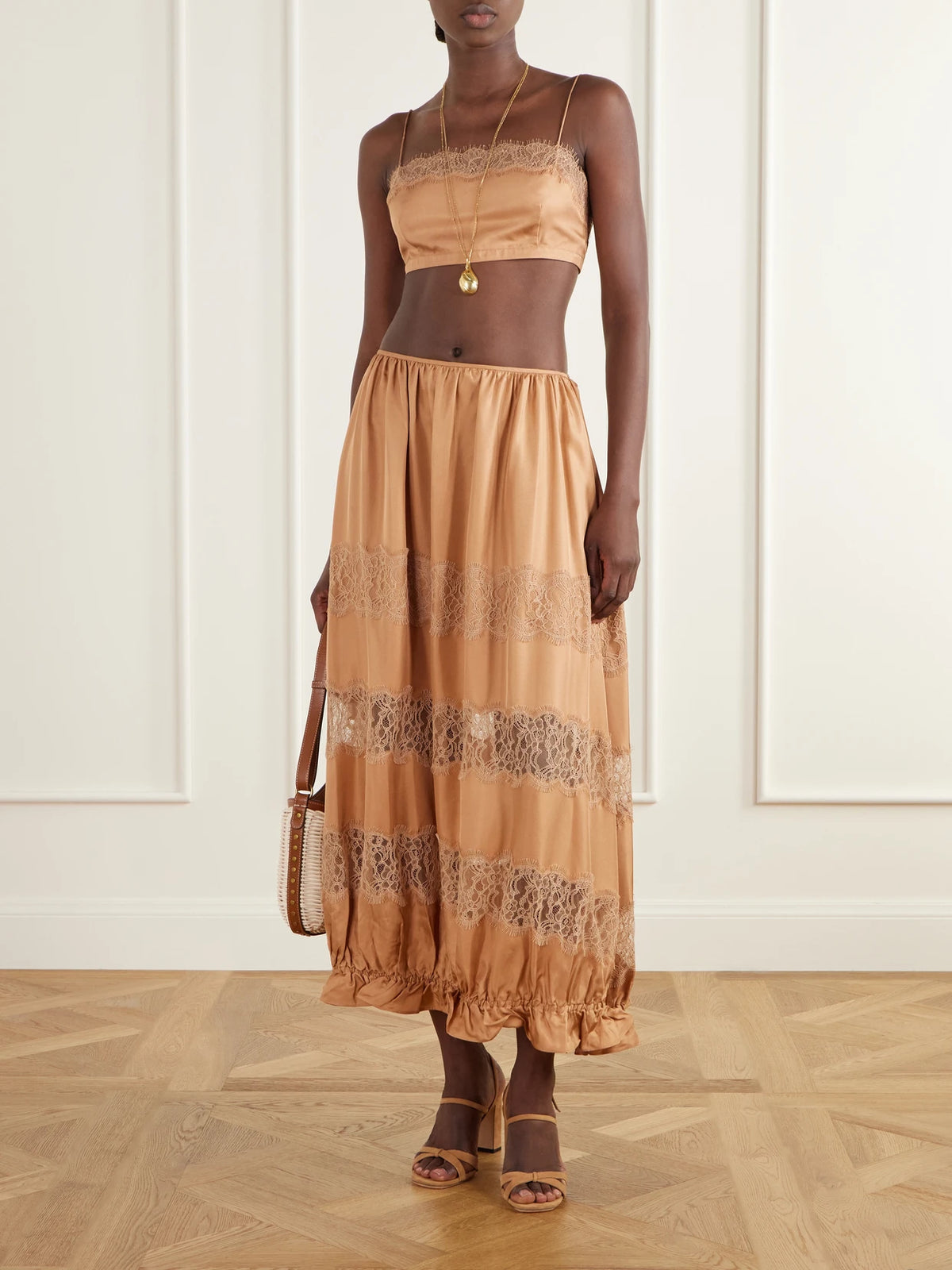 Image of a model wearing Skirts. Product name - Chantal Tiered Gathered Lace-trimmed Silk-charmeuse Midi Skirt in Camel colour by brand - Ulla Johnson