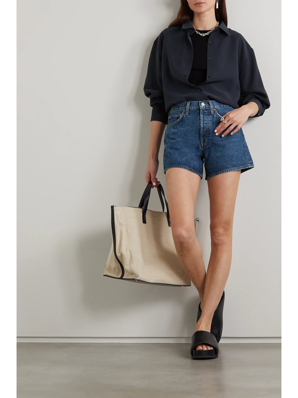 Image of a model wearing Shorts. Product name - Parker Long Clean Organic Denim Shorts in Dark denim colour by brand - AGOLDE