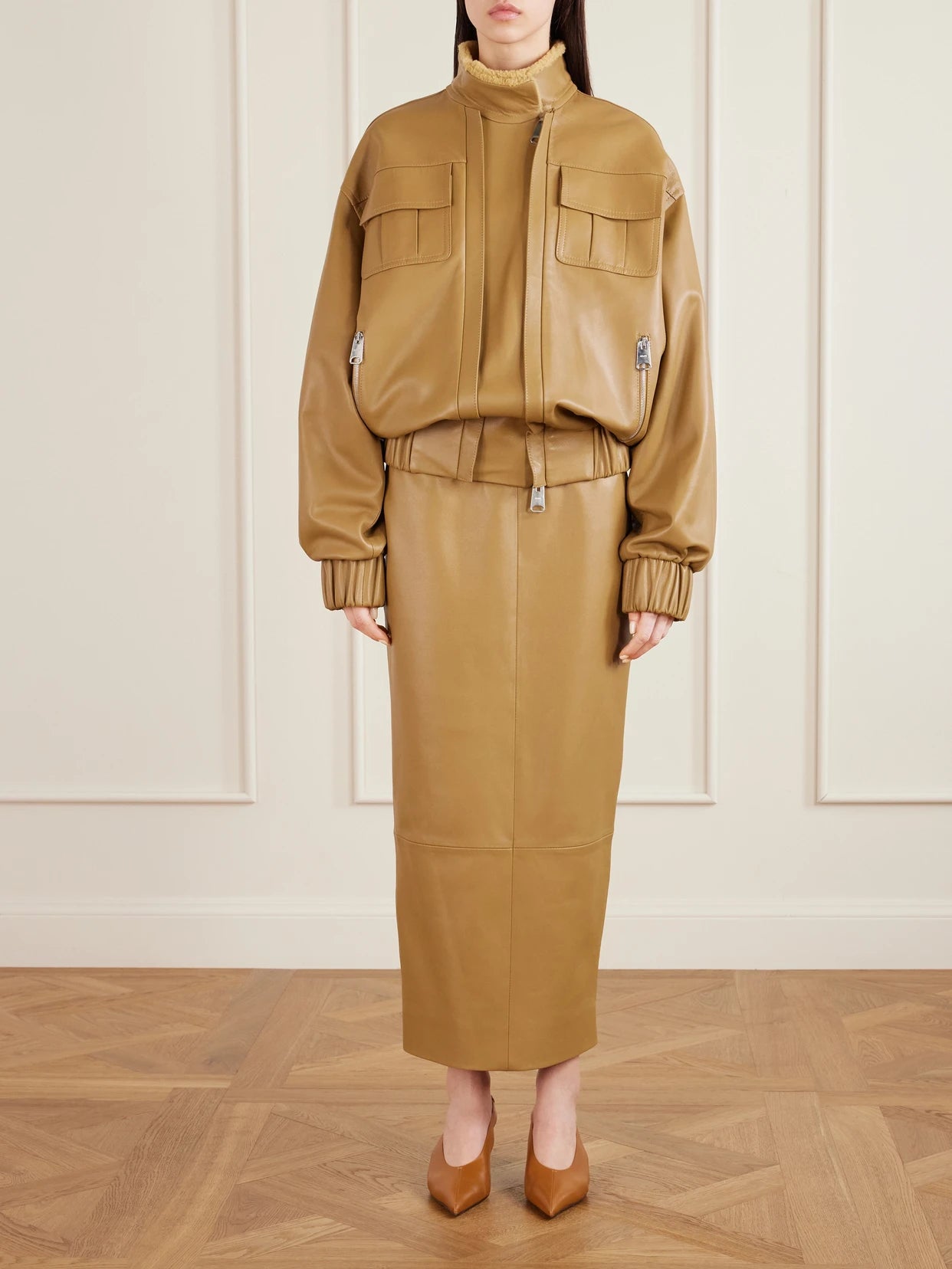 Image of a model wearing Skirts. Product name - Winton Paneled Leather Midi Skirt in Beige colour by brand - KHAITE