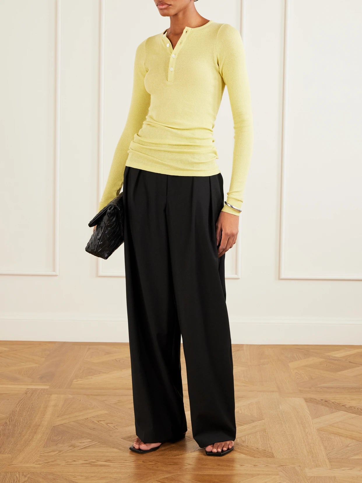 Image of a model wearing Tops. Product name - Ribbed-knit Cotton T-shirt in Pastel yellow colour by brand - Auralee