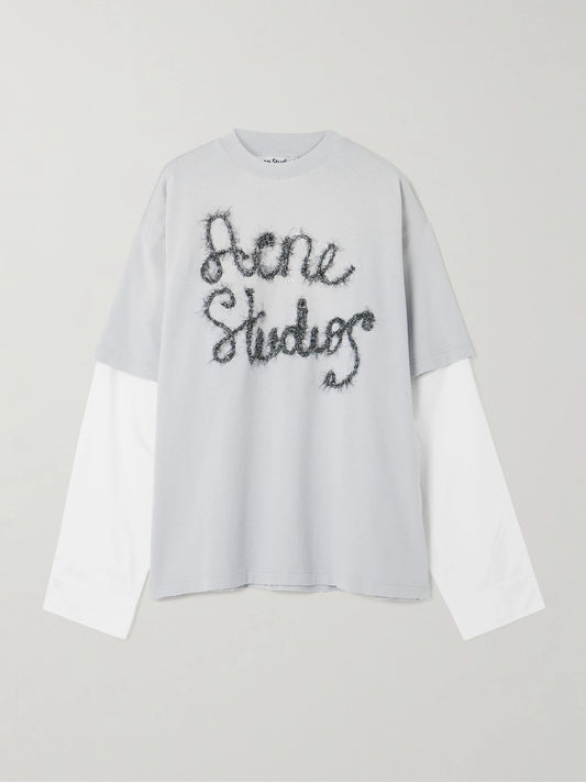Image of a model wearing Tops. Product name - Layered Embroidered Cotton-jersey And Poplin T-shirt in Light blue colour by brand - Acne Studios