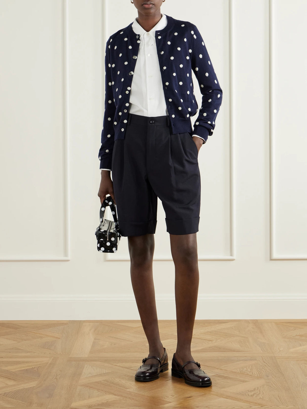 Image of a model wearing Shorts. Product name - Pleated Wool Shorts in Black colour by brand - Comme des Garçons GIRL