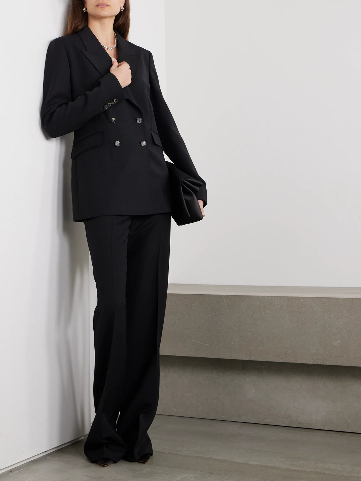 Image of a model wearing Outerwear. Product name - Angela Double-breasted Wool-crepe Blazer in Black colour by brand - Gabriela Hearst