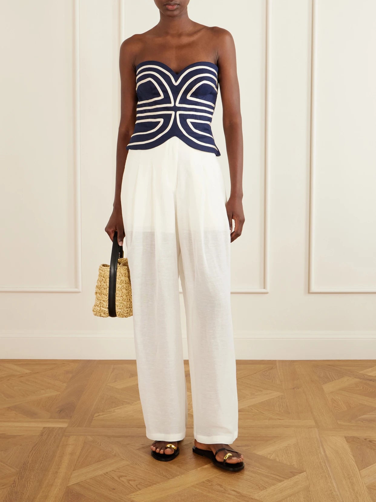 Image of a model wearing Tops. Product name - Serengeti Embroidered Linen-blend Top in Navy colour by brand - Andres Otalora