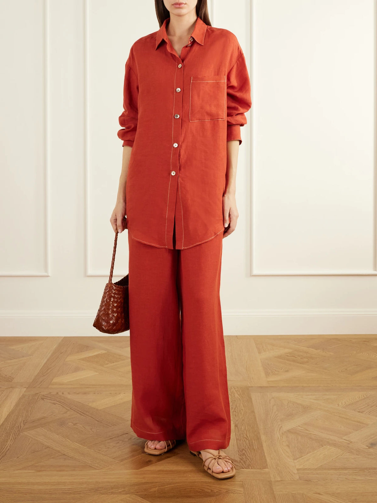 Image of a model wearing Tops. Product name - Flashing Woven Linen Shirt in Orange colour by brand - Eres