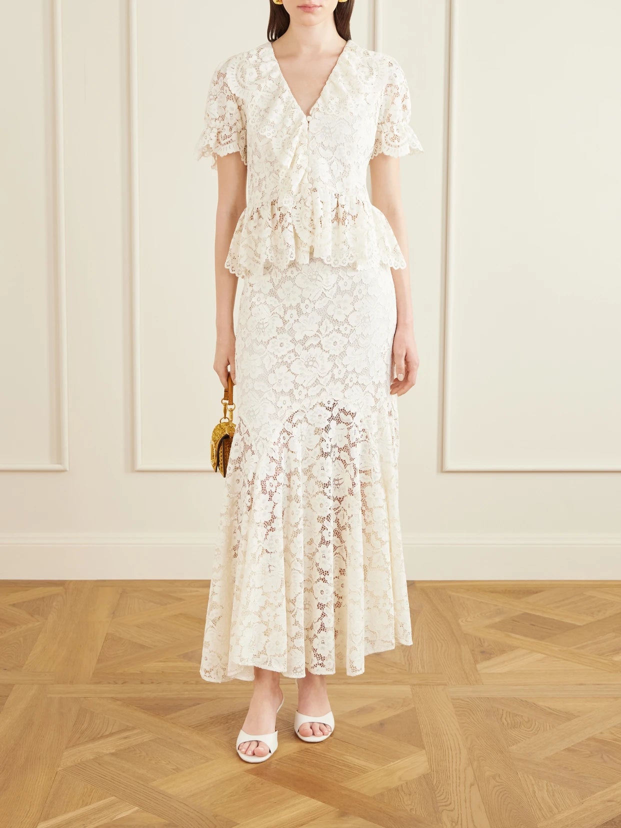 Image of a model wearing Skirts. Product name - Jade Pleated Lace Midi Skirt in Cream colour by brand - RIXO